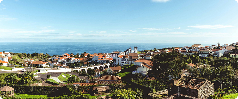 Vila costeira com casas e mar ao fundo